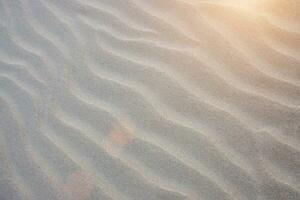 Sand lines on the beach with sunlight. photo