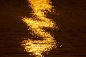 el agua superficie a el lago con ligero de puesta de sol. foto