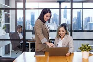 Businesswoman team leader is guiding young member to business success by showing information for goal achievement for startup and creativity project concept photo