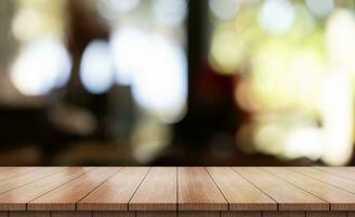 Empty wooden table top with lights bokeh on blur restaurant background. photo