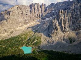 Aerial view of the blue turquoise Lake Sorapis, Lago di Sorapiss, with mountains with the background in Dolomites. One of the most beautiful lakes in Italy. Famous destination. photo