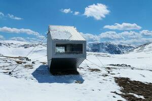 Mountain shelter for hikers and mountaineers during winter time. Alpinism activity. Mountains full of snow. Connect with nature. Outdoors activity and traveling lifestyle. photo