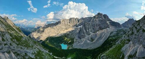 Panorama view of the blue turquoise Lake Sorapis, Lago di Sorapiss, with mountains with the background in Dolomites. One of the most beautiful lakes in Italy. Famous destination. photo