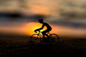 siluetas ciclistas en el playa a puesta de sol. foto