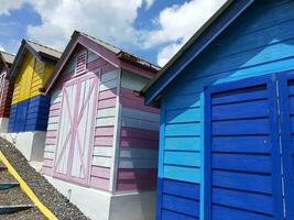 Colorful wooden houses in a row in a public park. Colorful beach huts. photo
