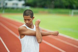 atletas deportistas corredores con ropa deportiva blanca para estirarse y calentarse antes de practicar en una pista de atletismo en un estadio. concepto de deporte de corredor. foto