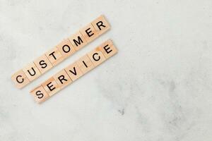 Top view of Customer Service word on wooden cube letter block on white background. Business concept photo