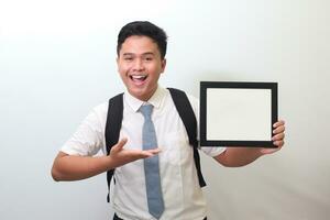 Indonesian senior high school student wearing white shirt uniform with gray tie showing empty frame. Blank space for typography or text to fill. Isolated image on white background photo