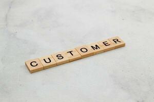 Top view of Customer word on wooden cube letter block on white background. Business concept photo