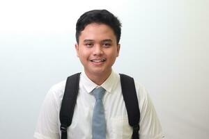 Indonesian senior high school student wearing white shirt uniform with gray tie smiling and looking at camera. Isolated image on white background photo