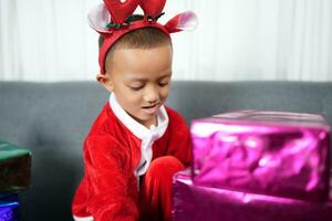 Merry Christmas 2024 concept Boy receives a gift from his mother at christmas photo