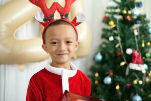 Merry Christmas 2024 concept Boy receives a gift from his mother at christmas photo