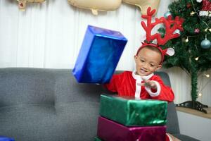 Merry Christmas 2024 concept Boy receives a gift from his mother at christmas photo