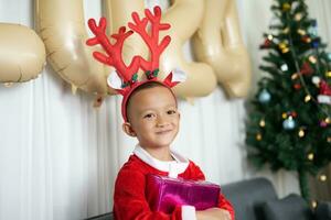 Merry Christmas 2024 concept Boy receives a gift from his mother at christmas photo