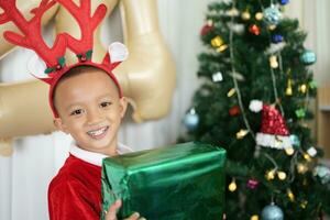 Merry Christmas 2024 concept Boy receives a gift from his mother at christmas photo