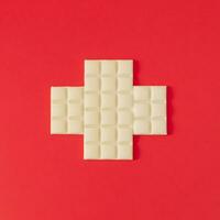 Flag of Switzerland made with white chocolate. Realistic aesthetic look. Minimal concept. Trendy Swiss flag and white chocolate idea. Yummy chocolate bars composition. Unique flat lay background. photo