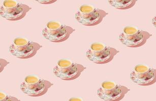 Trendy pattern made of floral cup of coffee on light pastel peachy pink background. Minimal concept. Creative coffee pattern idea. Fancy peachy pink background. Coffee aesthetic. photo