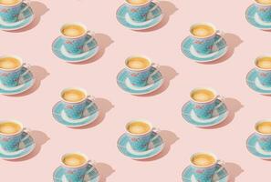 Trendy pattern made of blue cup of coffee on light pastel peachy pink background. Minimal concept. Creative coffee pattern idea. Fancy peachy pink background. Coffee aesthetic. photo