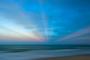 Seascape with sun beams at sunset photo