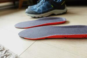men hand putting Orthopedic insoles in shoes photo