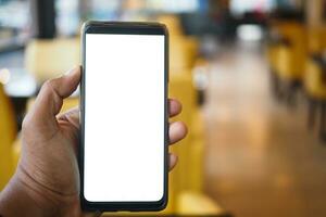 mano de hombre joven usando un teléfono inteligente con pantalla blanca en el café foto