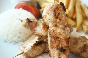 Chicken skewers with french fries and rice photo