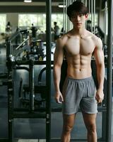 AI generated Young Asian male model, bright smile, good figure, exercise background at the gym, high resolution. The whole picture is sharp. Generate AI photo