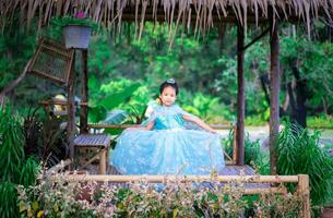 Portrait of cute smiling little girl in princess costume standing in the hut photo