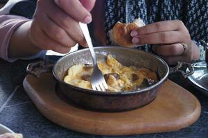 Turkish scrambled eggs with roasted meat in copper pan photo