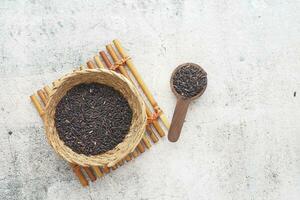 Black Rice Grains in a wooden bowl . photo