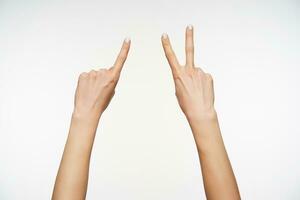 horizontal foto de Piel blanca joven señoras brazos demostración cuatro dedos mientras demostrando contando gesticulando en firmar idioma, aislado terminado blanco antecedentes