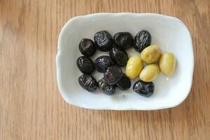 Collection of black and green olives with leaves. photo