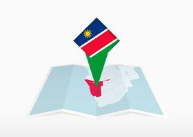 Namibia es representado en un doblada papel mapa y clavado ubicación marcador con bandera de Namibia. vector