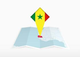 Senegal es representado en un doblada papel mapa y clavado ubicación marcador con bandera de Senegal. vector