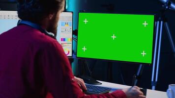 Photographer using advanced photo editing software on green screen monitor to make improvement to images quality. Photo editor utilizing specialized photographs retouching application on mockup PC video