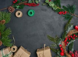 Christmas wreaths, fir branches and gifts on a black background. View from above photo