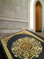 Book cover of holy Quran with bokeh background of mosque wall. Quran with bokeh background. Quran recitation in Ramadan. photo