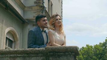 une Jeune couple dans l'amour avec deux gens permanent sur une pierre balcon et à la recherche dans chaque autres yeux. une Regardez dans le yeux de Jeune gens dans l'amour. aimant Regardez de Jeune gens video