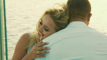 The bride puts her head on the groom's shoulder. The bride closeup smiles, hand straightens a lock of hair video