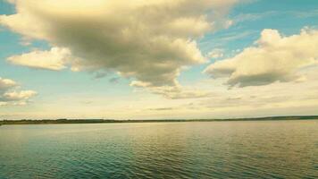 cinematográfico aéreo pôr do sol Visão sobre a lago. nuvens pendurado sobre a horizonte e a lago. crepúsculo video