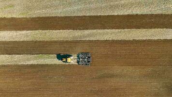 preparazione il suolo per piantare un' nuovo Ritaglia, agricoltura concetto, aereo superiore Visualizza di il campo e un' trattore aratura il suolo video
