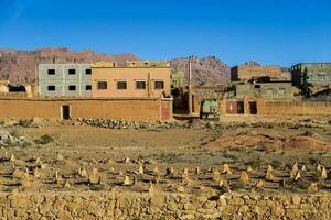 a village in the desert with buildings and mountains in the background photo