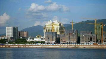 torre grua operando a desarrollo sitio, ciudad, grua y construcción con Departamento edificios, propiedad desarrollo, infraestructura, urbano paisaje, civil ingeniería, casino edificios en Laos video