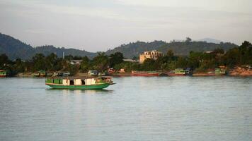 långsam båt cruising längs de mekong flod, lokal- båt rör på sig på mekong flod mellan de gräns av thailand och laos, båt transport på de flod, transport fartyg video