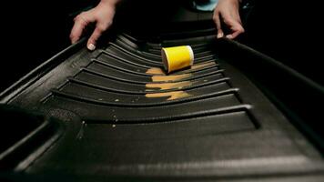 une verre de café déversé sur le voiture tapis. le mains de le chauffeur tirant le tapis en dehors de le auto. video