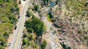 un secado río en un rocoso montañoso área. la carretera y carros cerca el río video