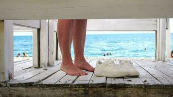 vrouw in de veranderen, dressing kamer Aan de strand, Bij zonsondergang Aan de kust. de meisje veranderingen kleren, het werpen omhoog een zwempak, vervolgens bladeren de kastje kamer in een roze jurk. dichtbij omhoog, langzaam beweging video