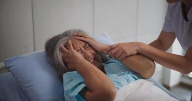 Portrait of Elderly female patient who was hospitalized was holding her head on the hospital bed in pain,severe headache photo