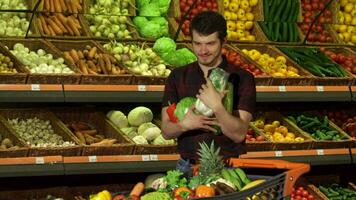 Mens zet verschillend groenten in de boodschappen doen kar video