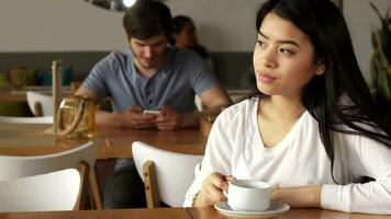 Girl leans her chin on her hand at the cafe video